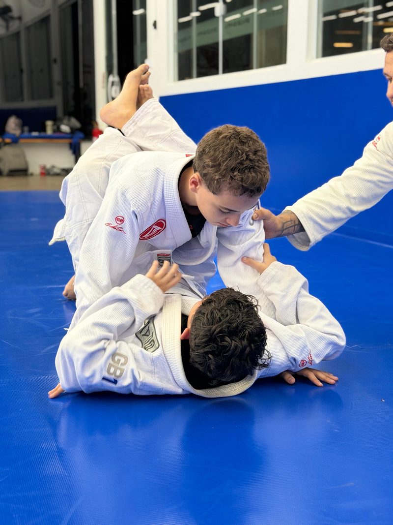 Dois alunos juniores treinando de perto no tatame