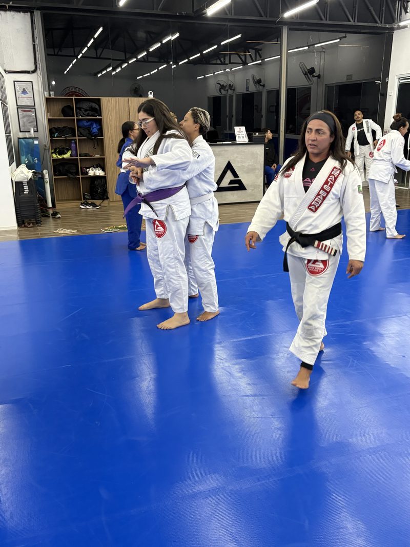 Professora Vanessa Silva circulando pelo tatame, atenta à turma